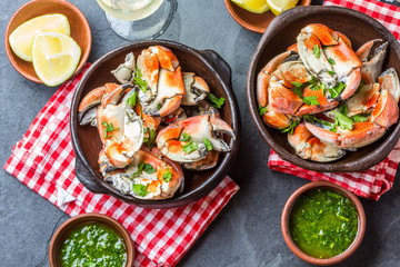 Crabs tentacles with wite wine, lemon, herbs sauce, slate background