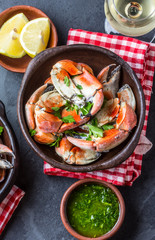 Crabs tentacles with wite wine, lemon, herbs sauce, slate background