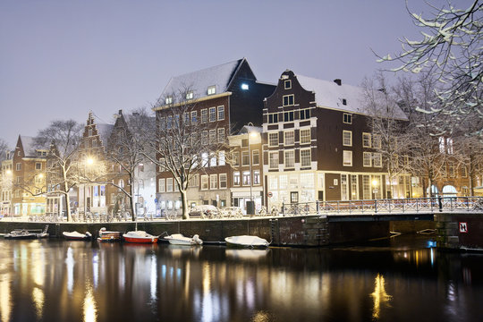 Amsterdam canals and typical houses on a snowy winter night