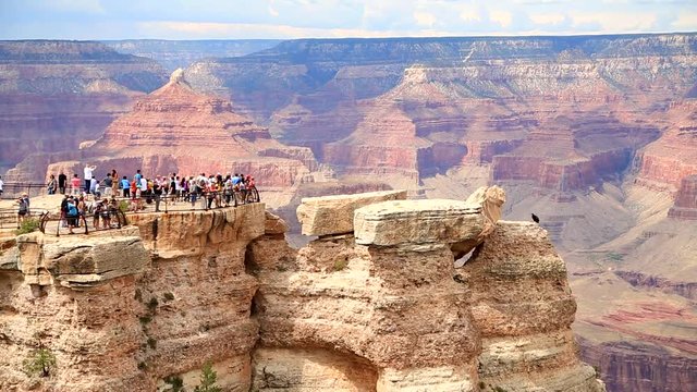 Unidentified tourists looking at the Grand Canyon. Attracts about five million visitors per year. It is one of the most remarkable natural wonders in the world.