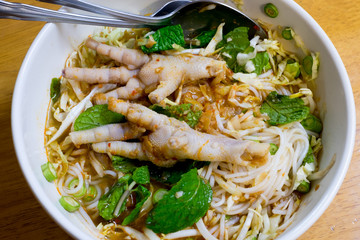 Thai vermicelli eaten with curry, Chicken foot and vegetable on wooden table