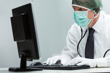 man with a surgical mask analizing a computer