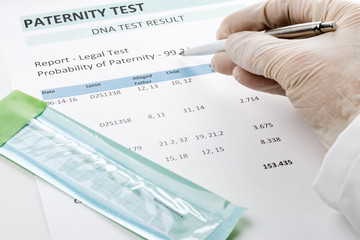 Doctor points at result on paternity test result form - obrazy, fototapety, plakaty