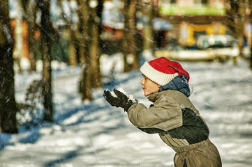 Happy boy playing with snow