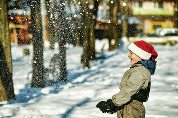 Happy boy playing with snow
