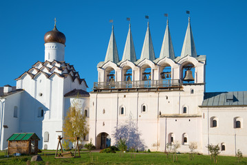 Fototapeta na wymiar Bell tower and the intercession Church of the Tikhvin assumption monastery closeup. Sunny October evening. Tikhvin, Russia
