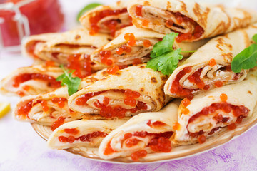 Pancakes with red caviar on plate. Russian cuisine. Maslenitsa