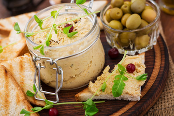 Pate Chicken - rillette, toast, olives and herbs on a wooden board