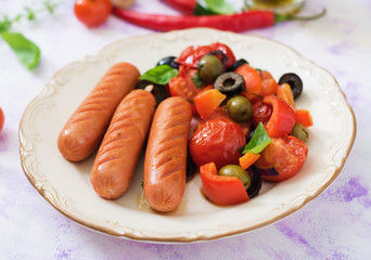 Sausages grilled with vegetables in the Greek style on plate.