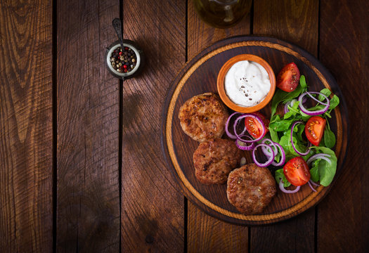 Appetizing meat cutlet and tomato salad with arugula