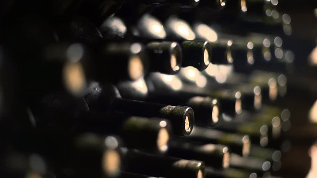 wine bottles stacked in a cellar with shallow depth of field