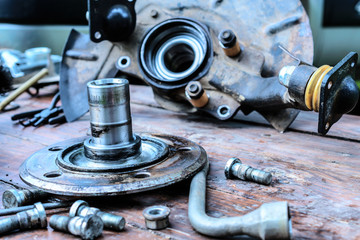 Old, oiled wheel hub lies on a wooden table