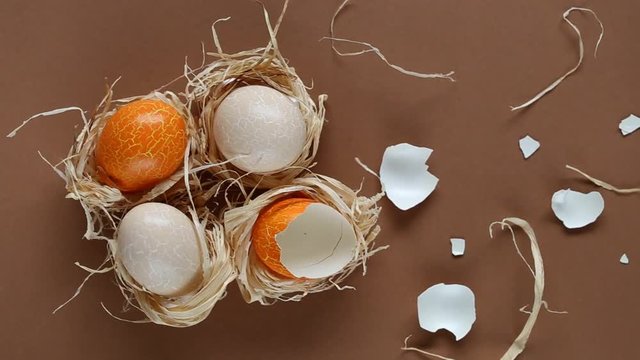Easter concept. three eggs and egg shell on a brown background