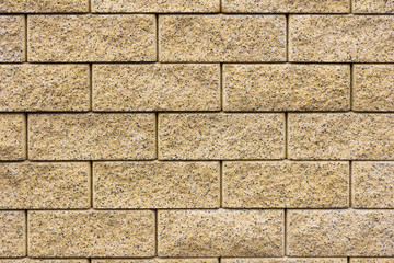 Amber or beige bricks in layers as a cladding of a wall