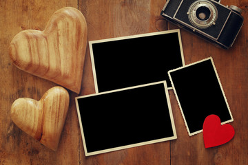 empty photo frames next to old camera and hearts