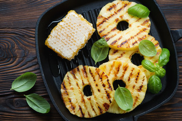 Cast-iron pan with bbq pineapple slices with addition of honey