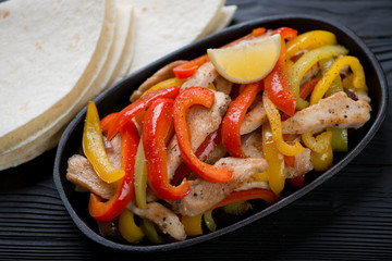 Close-up of a cast-iron pan with tex-mex chicken fajitas