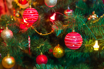 Christmas tree with red ball, decorations and hanging lights. Magic  holiday background. Close up