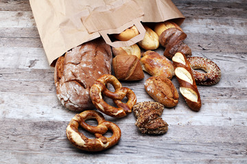 Different kinds of bread and  bread rolls on board from above. Kitchen or bakery poster design.
