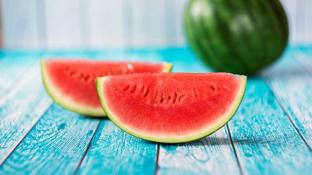 Watermelon slice popsicles on a blue rustic wood background. Selective focus