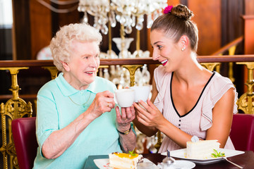 Senior woman and granddaughter at coffee in cafe
