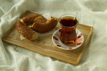 Morning turkish tea in traditional glass with bagel on the tray,