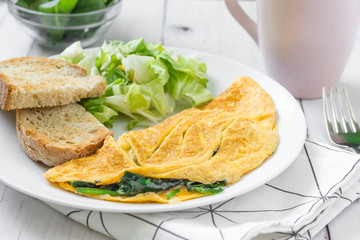 Omelette with spinach, fresh salad and toast.