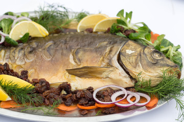 carp  with lemon, dill and raisins on plate