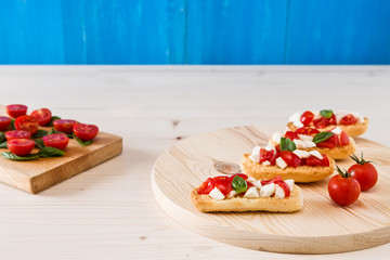 Italian crostini with mozzarella, cherry tomatoes and basil