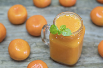 Freshly squeezed healthy citrus tangerine juice in jar and ripe