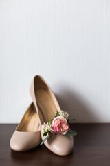 Bridal accessories: beige shoes and buttonhole. Wedding accessories: Bride's shoes and boutonniere