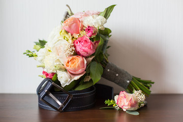 Groom's morning. Wedding accessories on wooden background. A belt, rings, watch, boutonniere. Preparing to wedding day