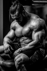 Brutal strong bodybuilder athletic men pumping up muscles with d