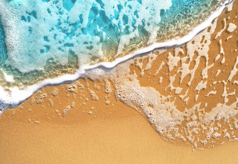 Background  with soft waves with foam blue ocean sea. Golden sunny sandy beach in the resort...