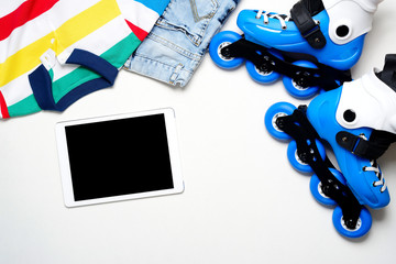 Sport, healthy lifestyle, roller skates and boy's clothing set, cell phone on white background