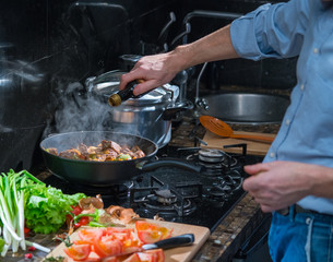 Man adds to the pan with the spices meat