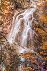 Fototapeta na wymiar waterfall in autumn with trees and warm autumn colors. Trees in autumn with yellow colors
