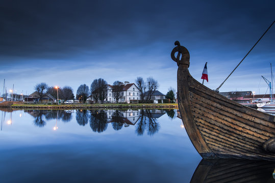 wooden ship in Carentan quay with reflections in water