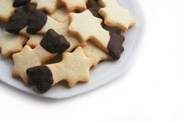 Biscotti al burro a forma di stella su piatto su sfondo bianco