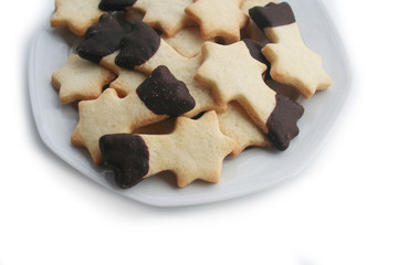 Biscotti al burro a forma di stella su piatto su sfondo bianco