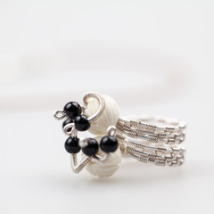 Silver jewels with onyx stones, bone beads, natural leather and light grey background