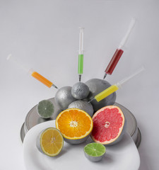 Injection into citrus fruits - orange, grapefruit, lemon, lime. Concept for genetically modified food. GMO.