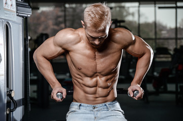 Fototapeta na wymiar Strong and handsome athletic young man muscles abs and biceps.