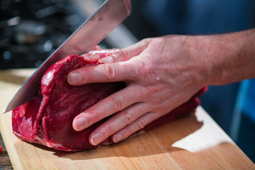 Obraz na płótnie Canvas The knife cuts a piece of meat in half