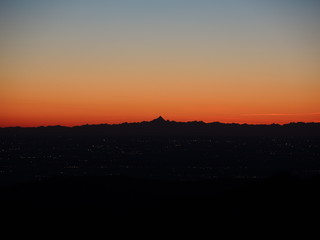 Fiery sunset from mountain pick with thin glazes in the sky evening. Fall season. Orobie alps. Rena pick. Bergamo Italy. In the distance the Monviso.