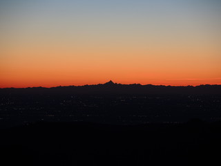 Fiery sunset from mountain pick with thin glazes in the sky evening. Fall season. Orobie alps. Rena pick. Bergamo Italy. In the distance the Monviso.