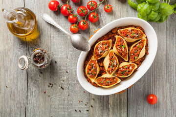Obraz na płótnie Canvas Italian pasta Conchiglioni Rigati stuffed with dry tomatoes and