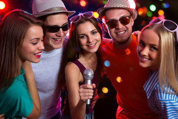 Happy people having fun singing at a party