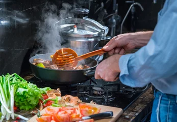 Crédence de cuisine en verre imprimé Cuisinier Man cooks food in a frying pan