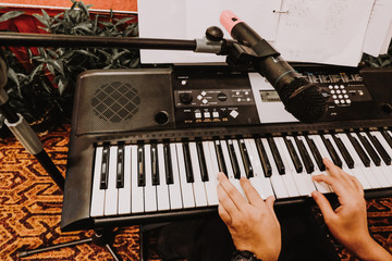 selective focus and closeup view of music instrument, man hand play synthesiser electronic keyboard 